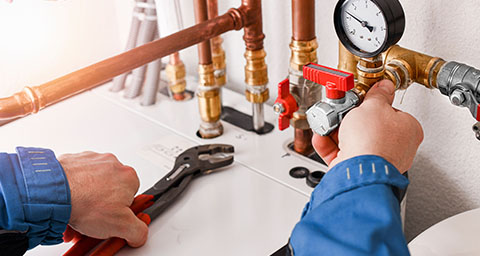 a person installing copper water pipes with a pressure gauge