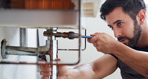 a man using a wrench to fix a boiler