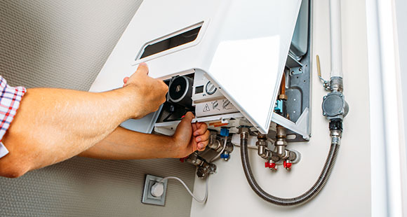 a man installing a water heater onto a wall