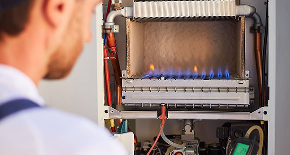 a man doing maintenance and check-up on a gas boiler